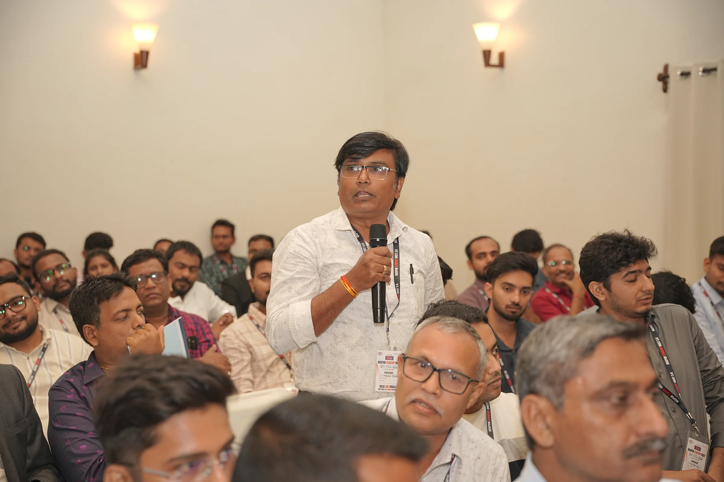Pravin Verma speaking with a microphone at the Nagpur Startup Meet